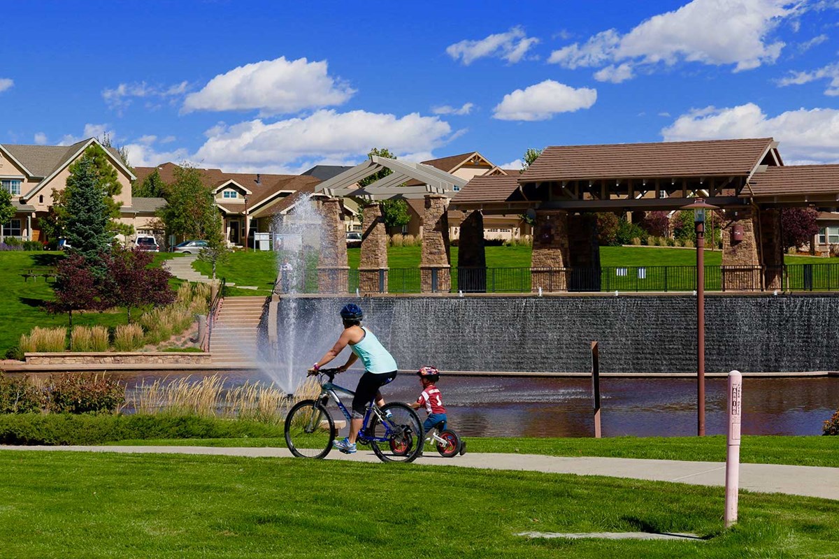 Family walking with a dog on a path through a master-planned community