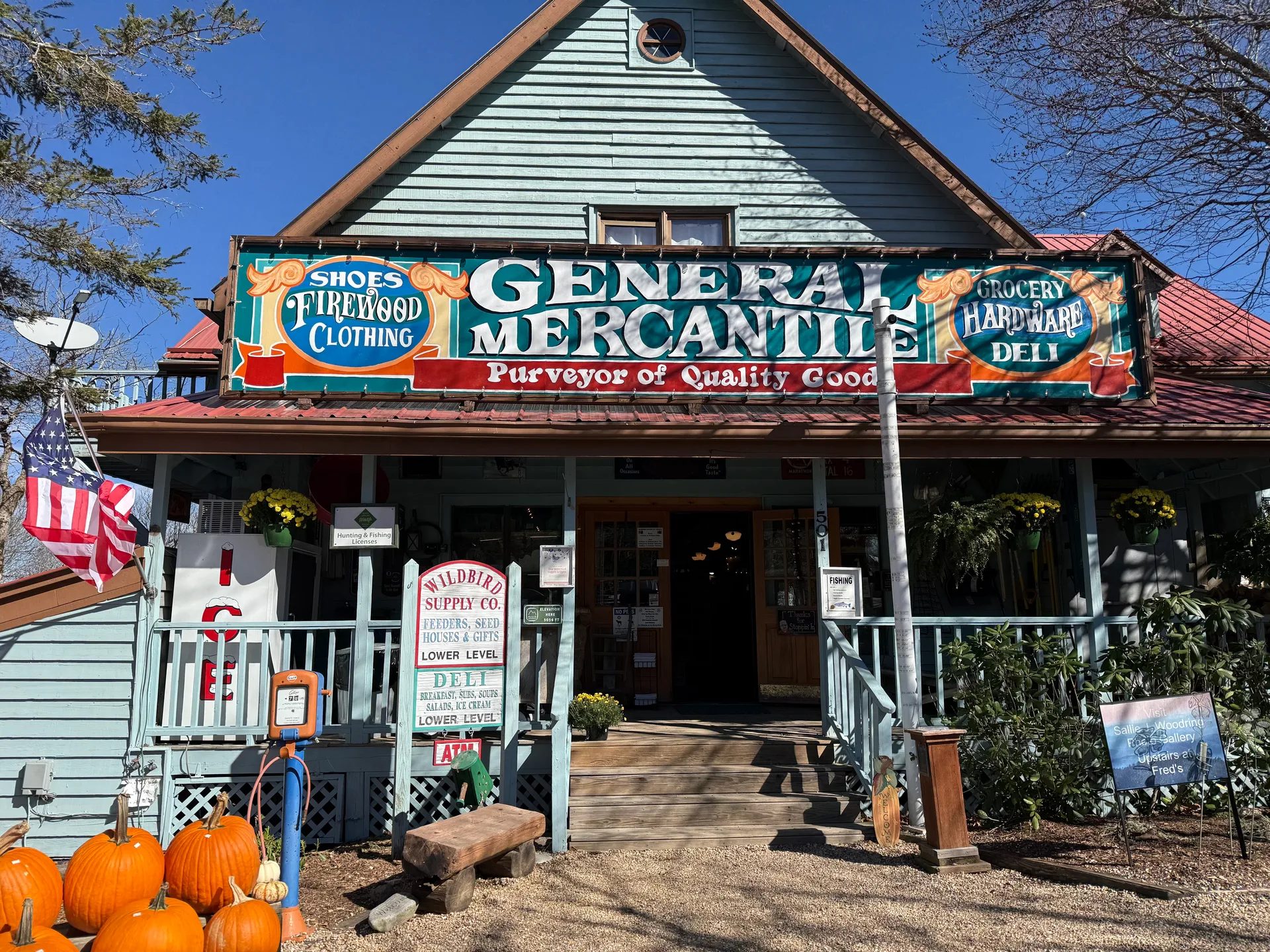 The Fred's Mercantile storefront, a rustic general mercantile building with a covered porch and signs for grocery, hardware, deli, shoes, clothing, and firewood