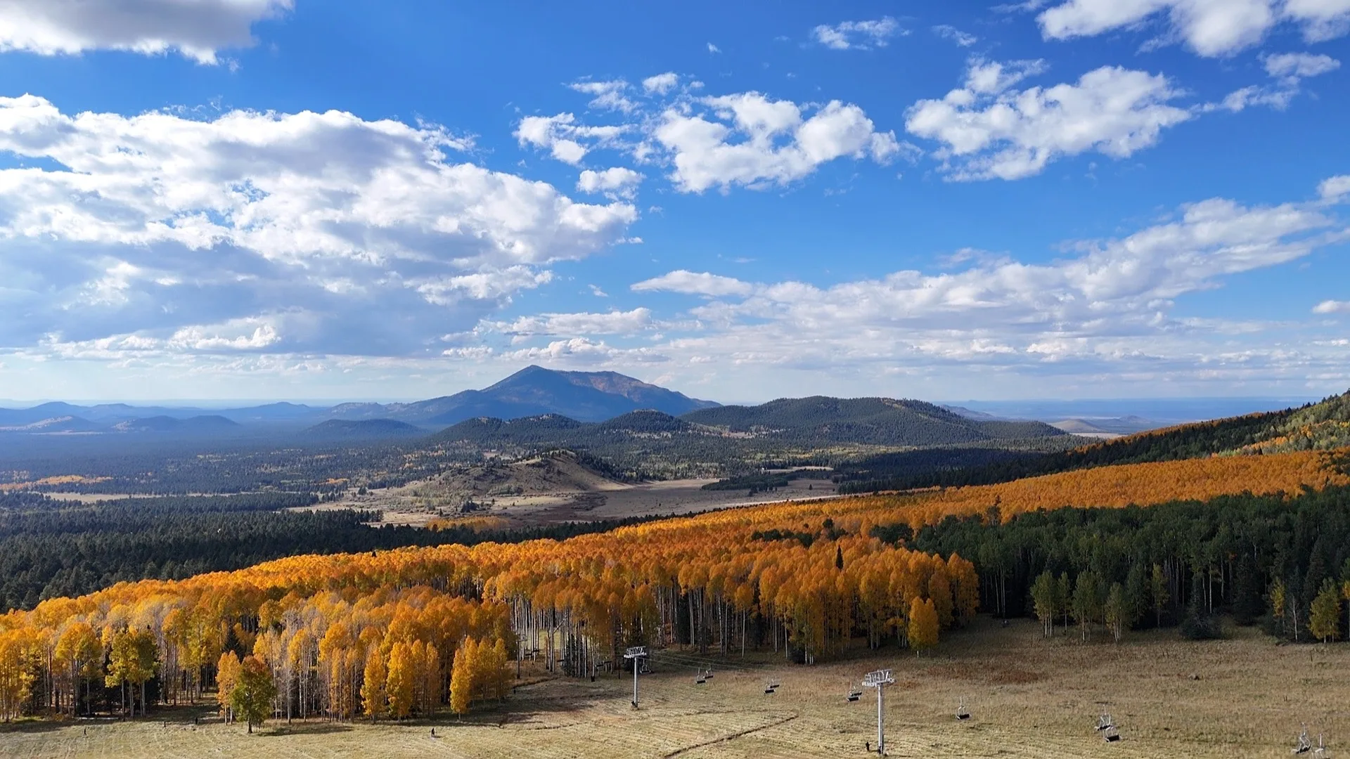 Drone view over Flagstaff toward the San Francisco Peaks in autumn light