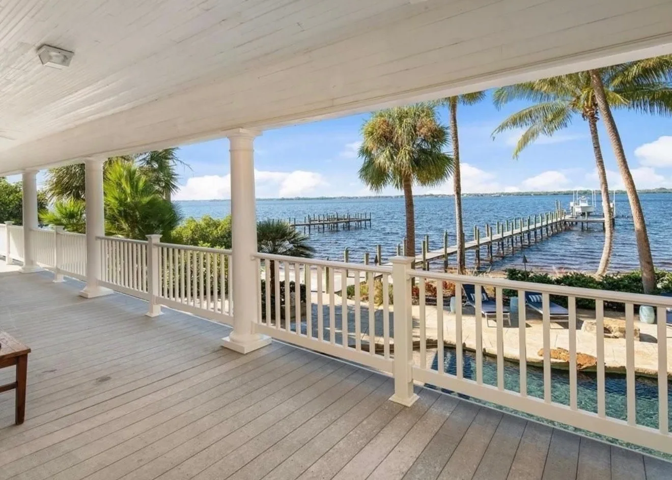Aerial view showing private sandy beach, docks with boat lift, and lush grounds along the Caloosahatchee River