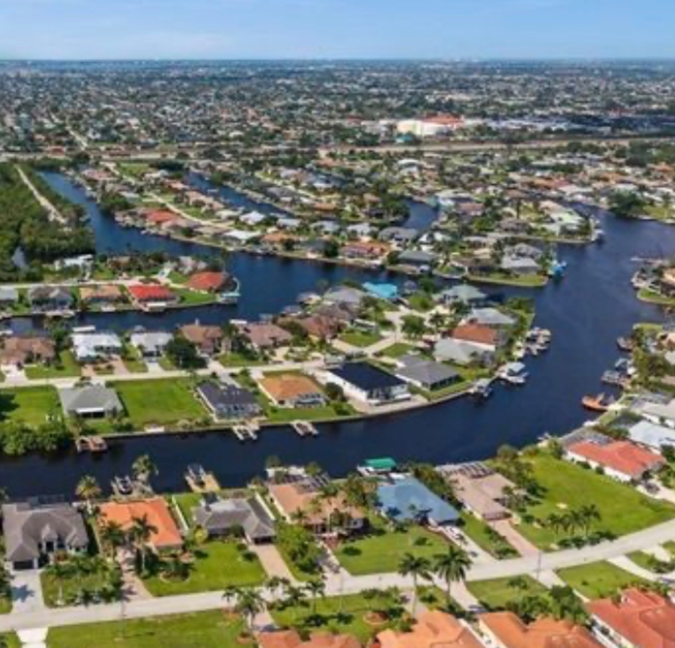 Cape Coral's extensive canal system stretching toward open water under a bright Florida sky