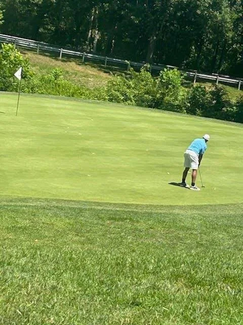 Golfer putting on the green at the FORE the KIDS Golf Tournament