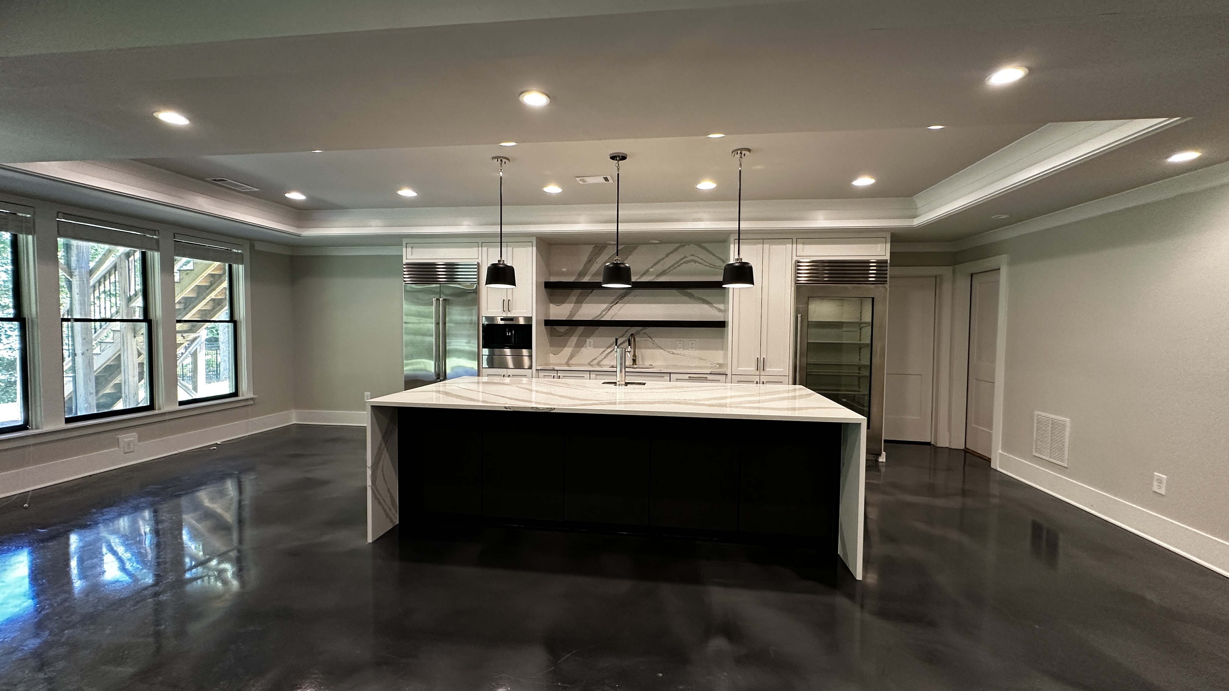 Kitchen at 5760 Lula Bridge Ct with island, pendant lights, and epoxy floor