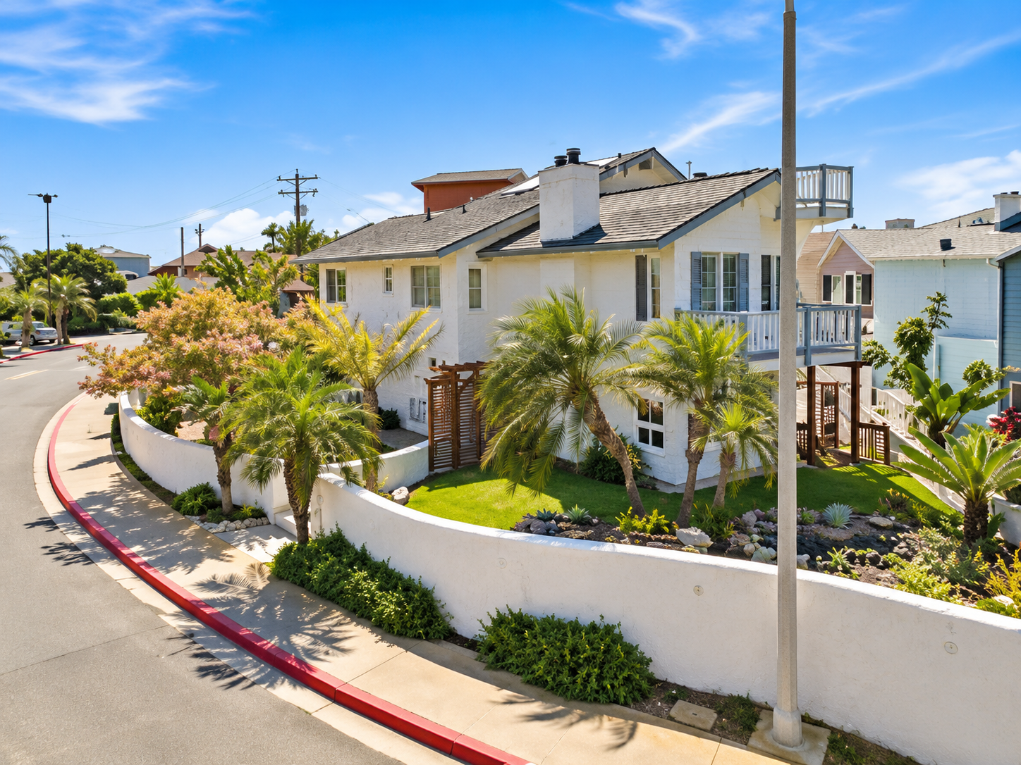 A master-planned family neighborhood street in Carlsbad at dusk with a warmly lit park pergola
