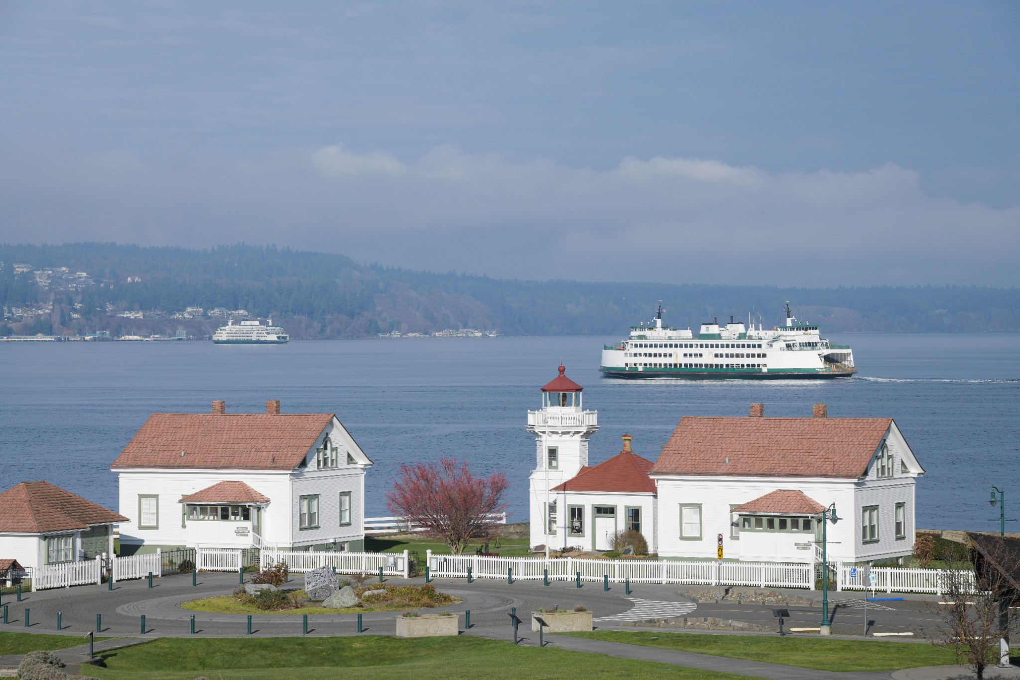 The Mukilteo Light Station with a Washington State ferry crossing Possession Sound in the background