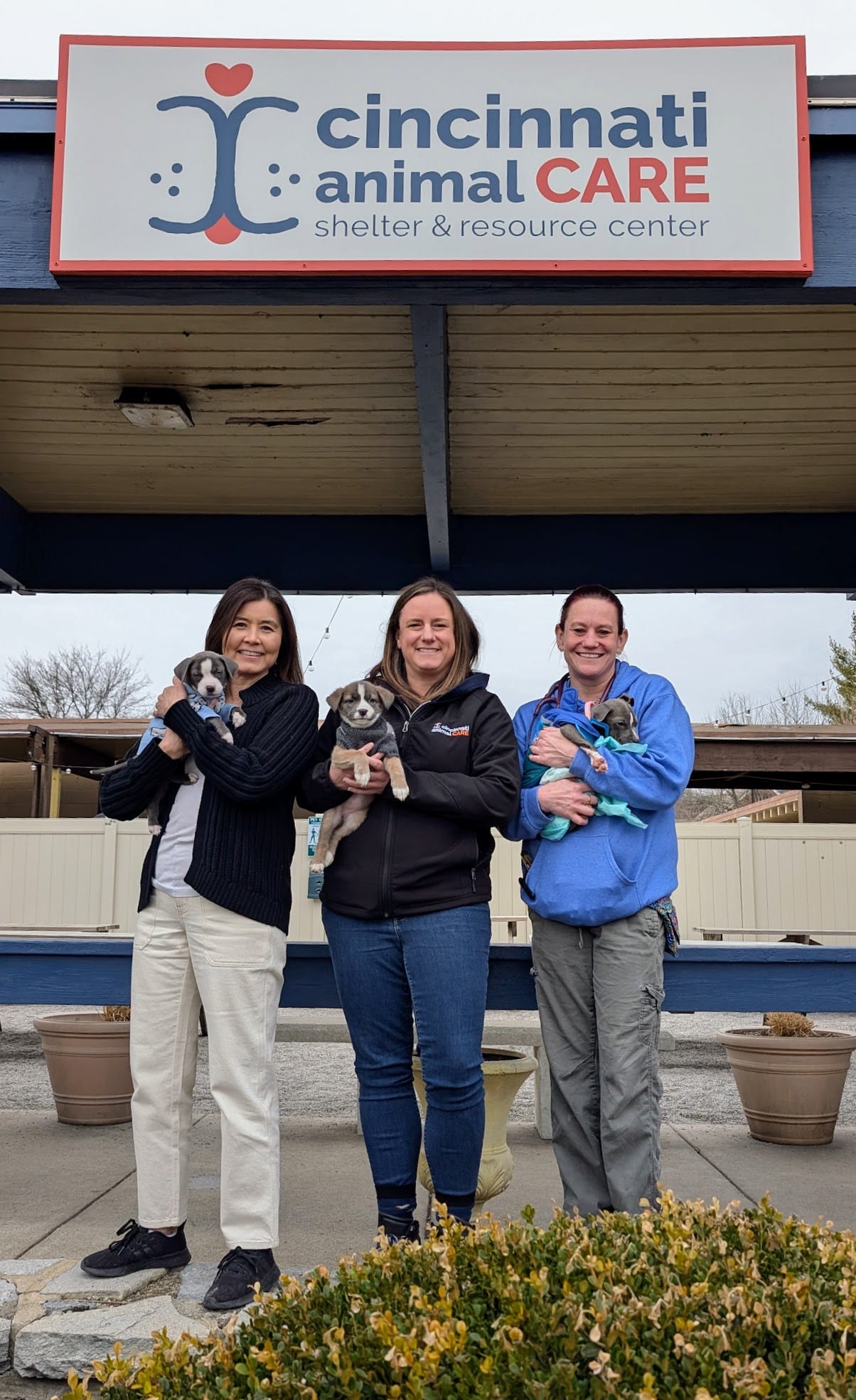 Cincinnati Animal CARE team members holding puppies outside the shelter and resource center.