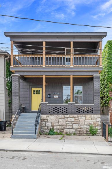 538 Harrison Street exterior showing the dark siding, yellow front door, and two-tier porch in Columbus Park