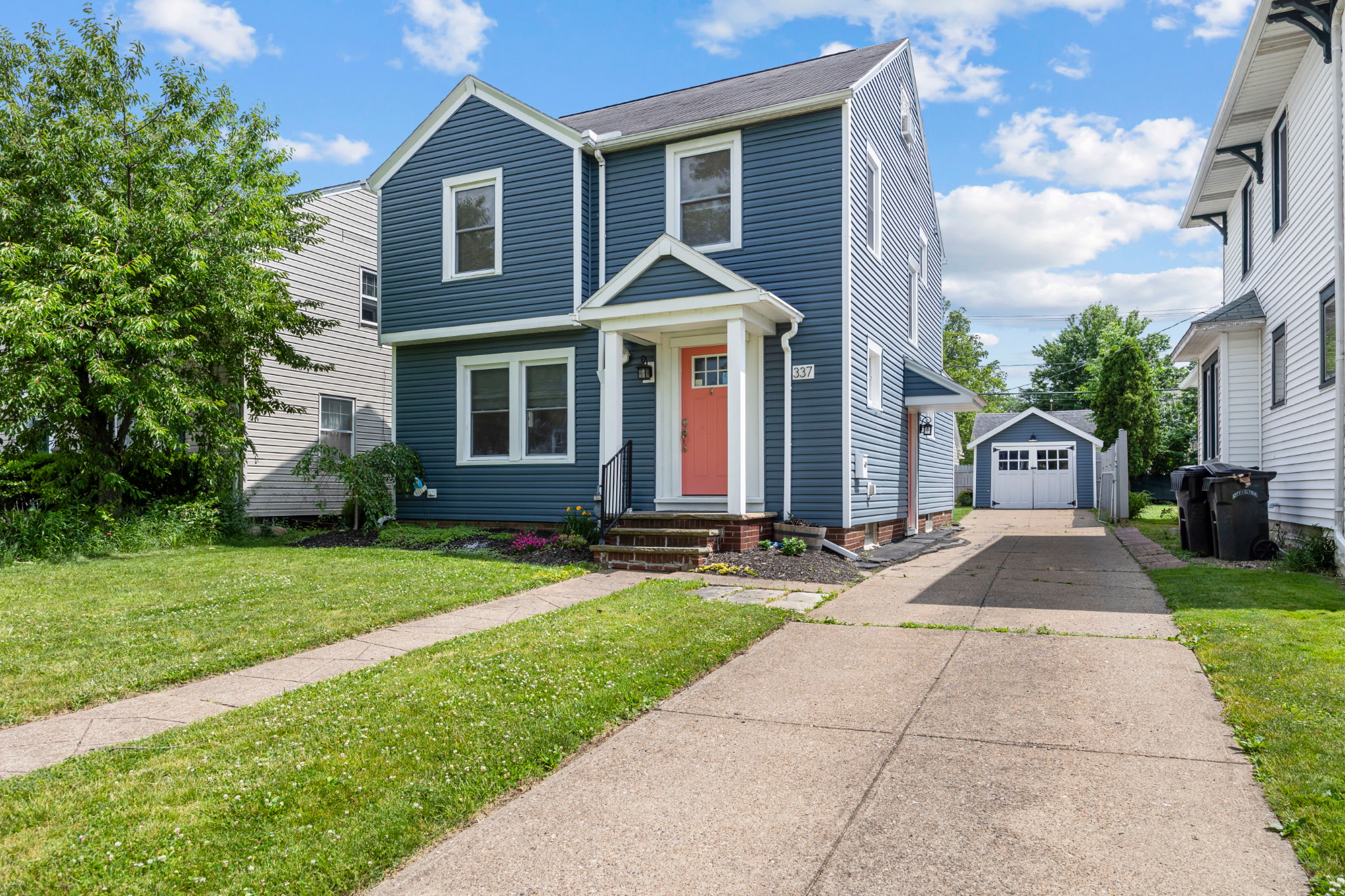 337 Harvard Ave, Elyria, OH 44053 — Colonial home with blue siding and coral front door by Gary & Kelly Post
