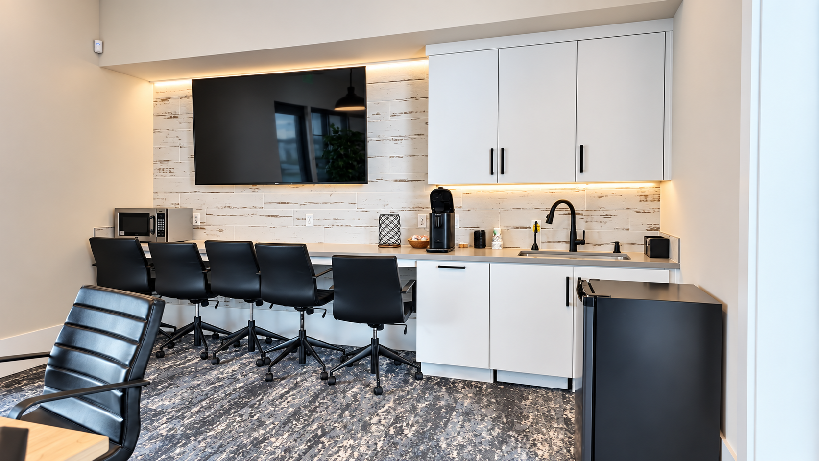 A workspace with a kitchenette and a row of desks in the business lounge at Club Liberty, Summit at Liberty, Rio Vista