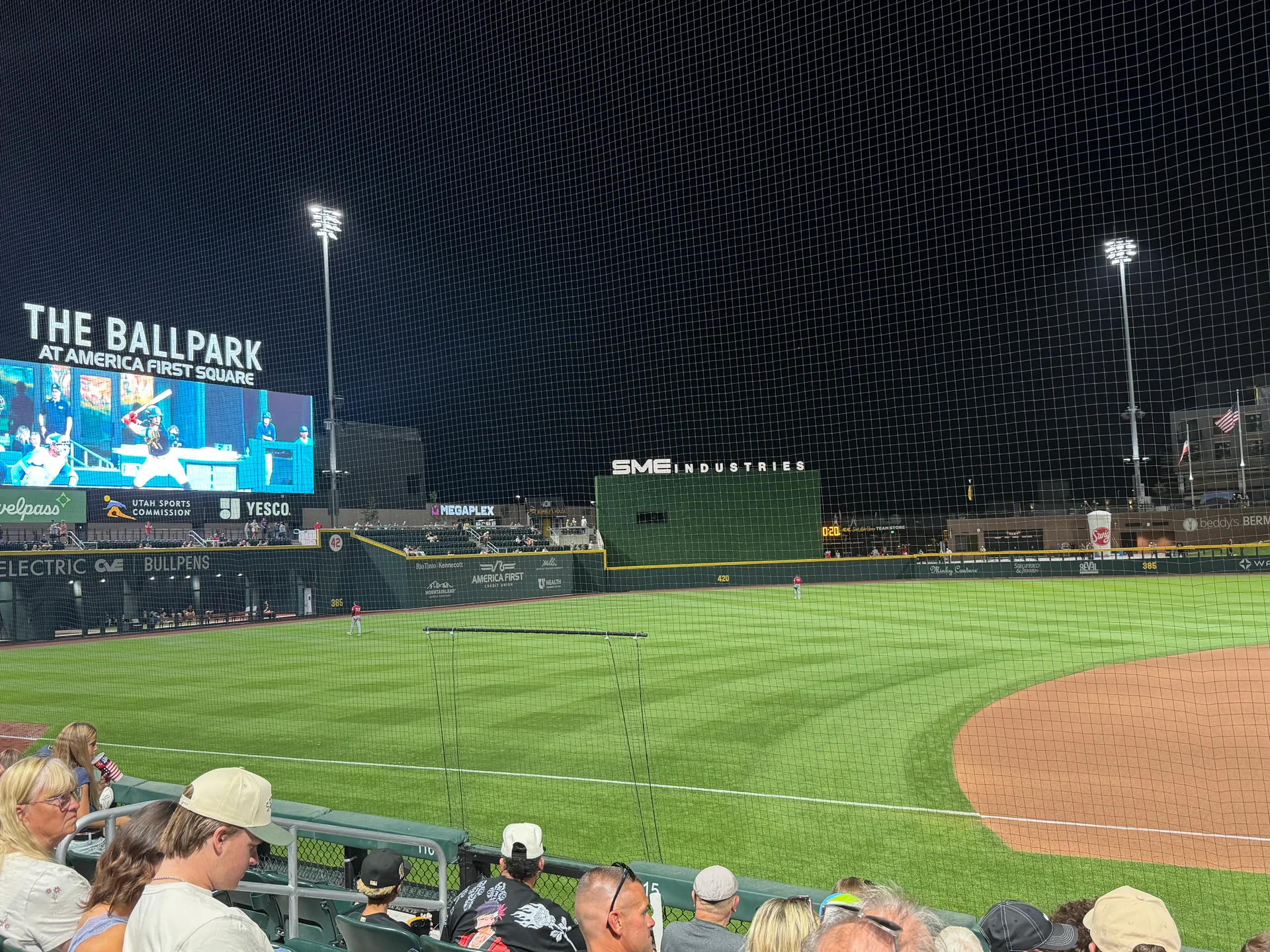 Salt Lake Bees fans cheering together at The Ballpark at America First Square on a summer evening