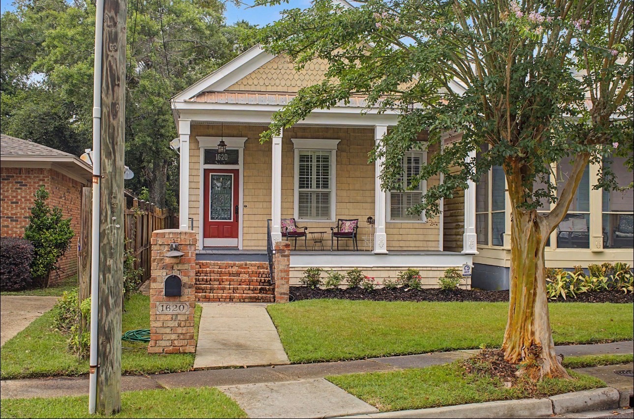 1620 2nd St, Gulfport, MS 39501 — tan siding, red door, white porch columns, and brick steps
