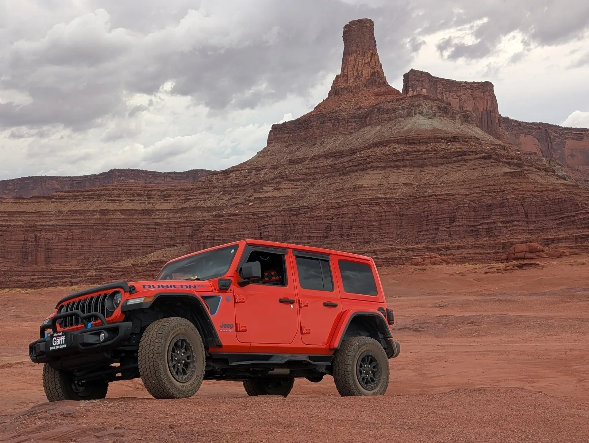 Heather Smith's bright orange Jeep Rubicon parked in a desert landscape with red rock formations
