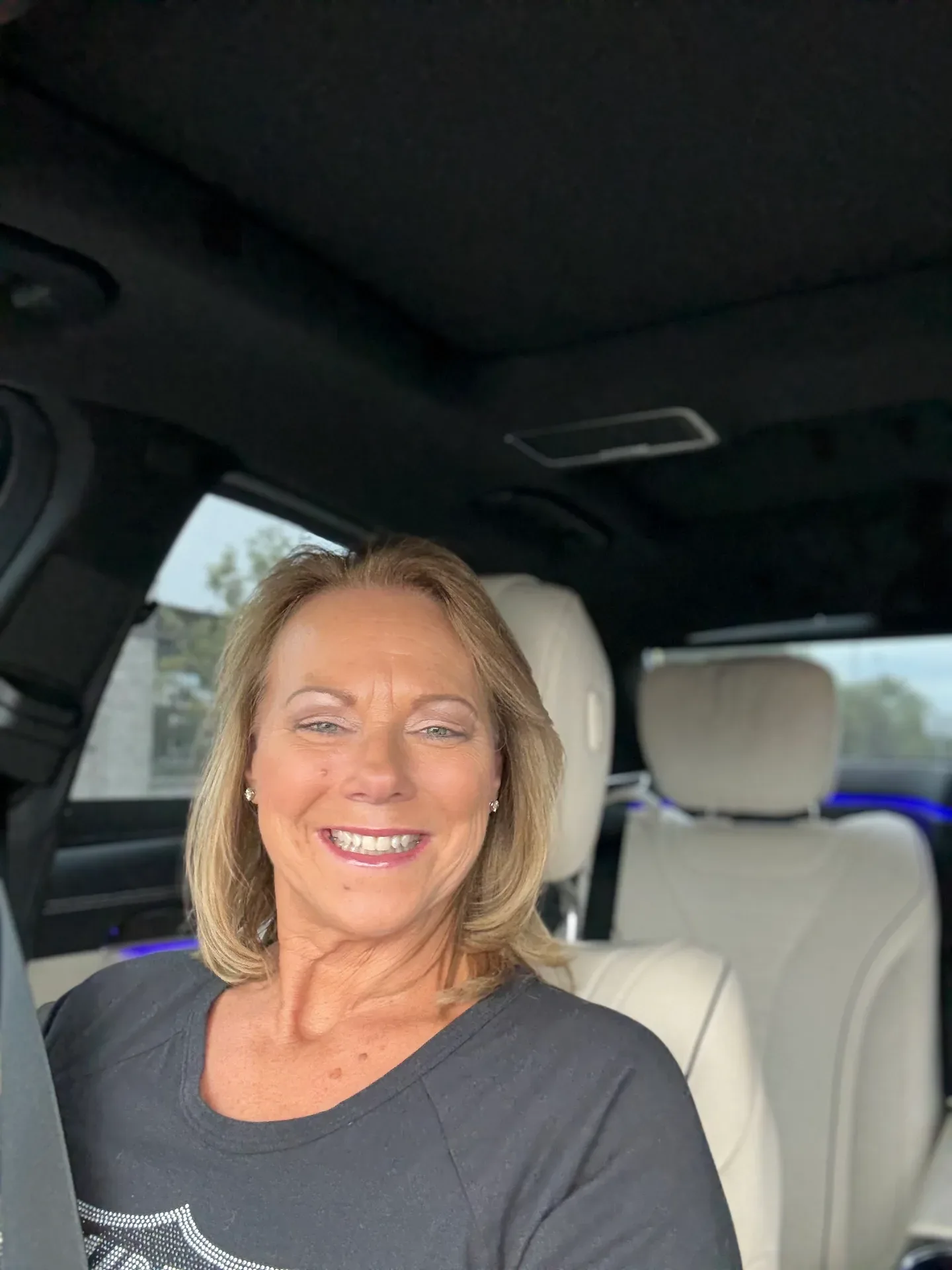 Bev Prock smiling in the driver's seat of her car