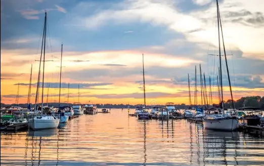 Sailboats docked in calm water at a Lake Norman marina at sunset