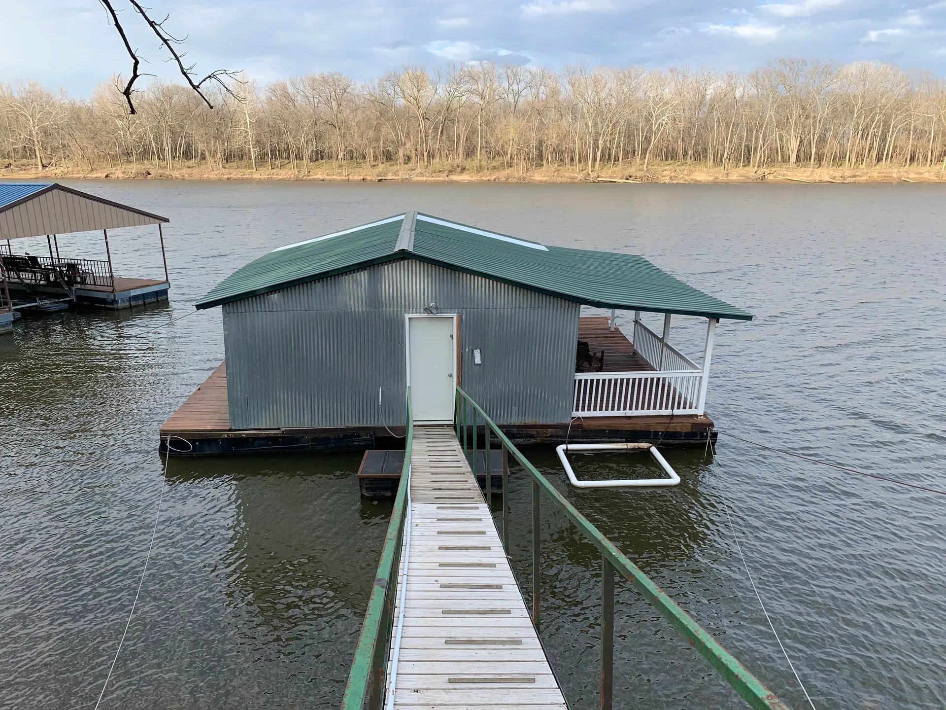 Covered boathouse floating on a calm lake near Pryor