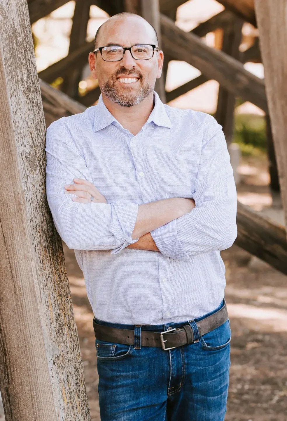 Craig Davis smiling in a professional headshot, wearing glasses and a button-down shirt