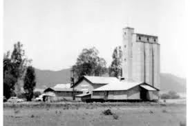 Black and white archival photograph of the Murrieta train depot with two figures standing in front