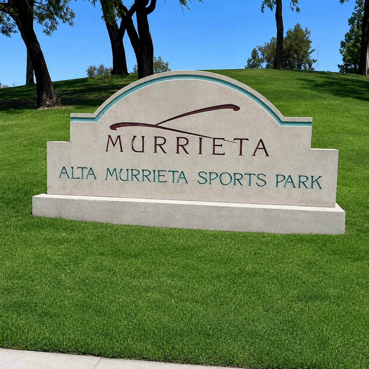 Alta Murrieta Sports Park entrance stone monument sign with colorful flowers and green grass