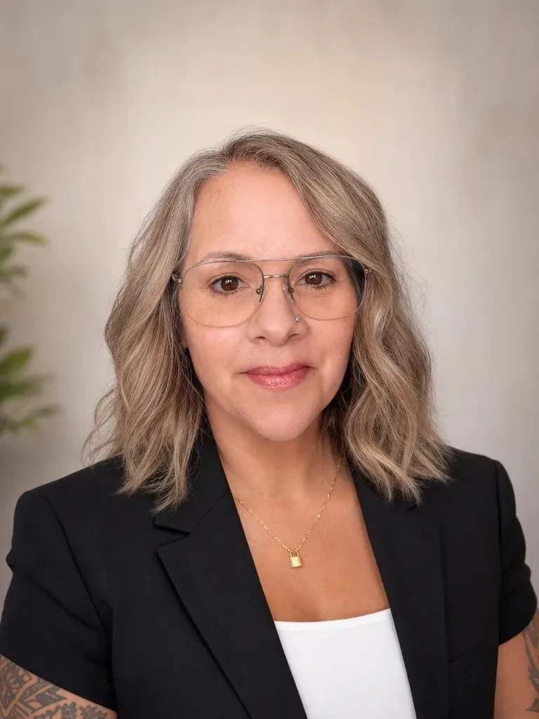 Katcina Smith, real estate broker with MORE Realty, in a black blazer and glasses