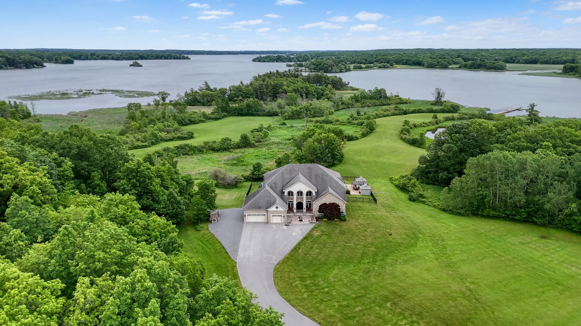 Aerial drone shot of a luxury waterfront property on a green estate in Kingston Ontario