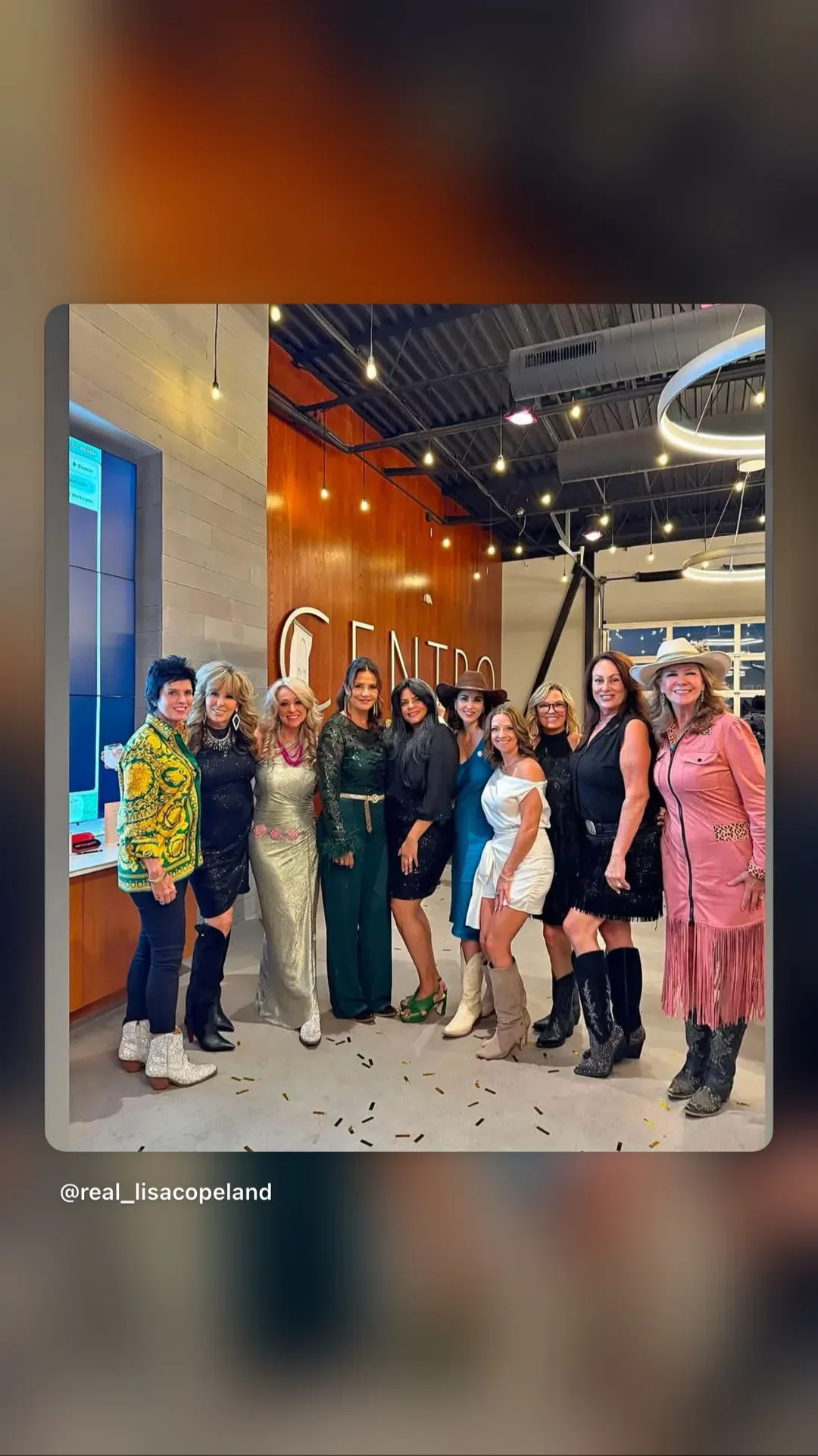 Lisa Copeland with ten women at an evening social event under modern lighting