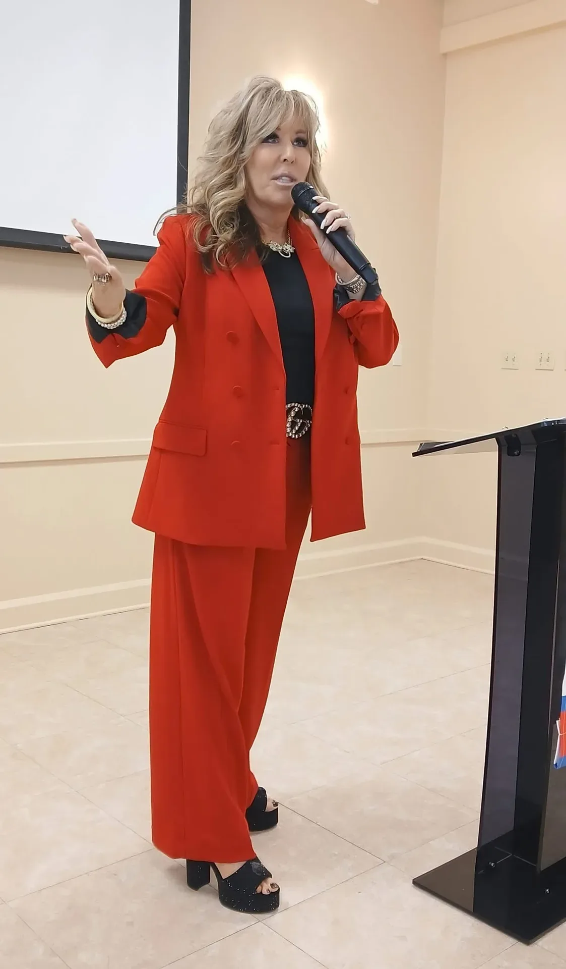 Lisa Copeland speaking in a red suit at a professional event