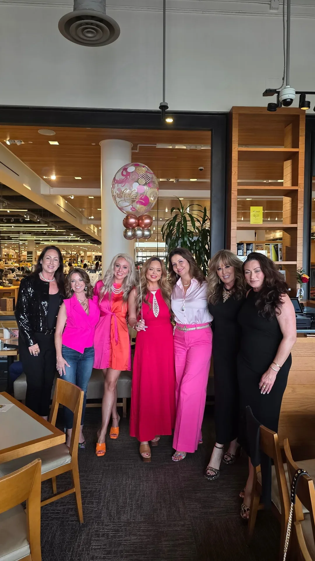 Lisa Copeland with seven women at a restaurant celebration with decorative balloon bouquet