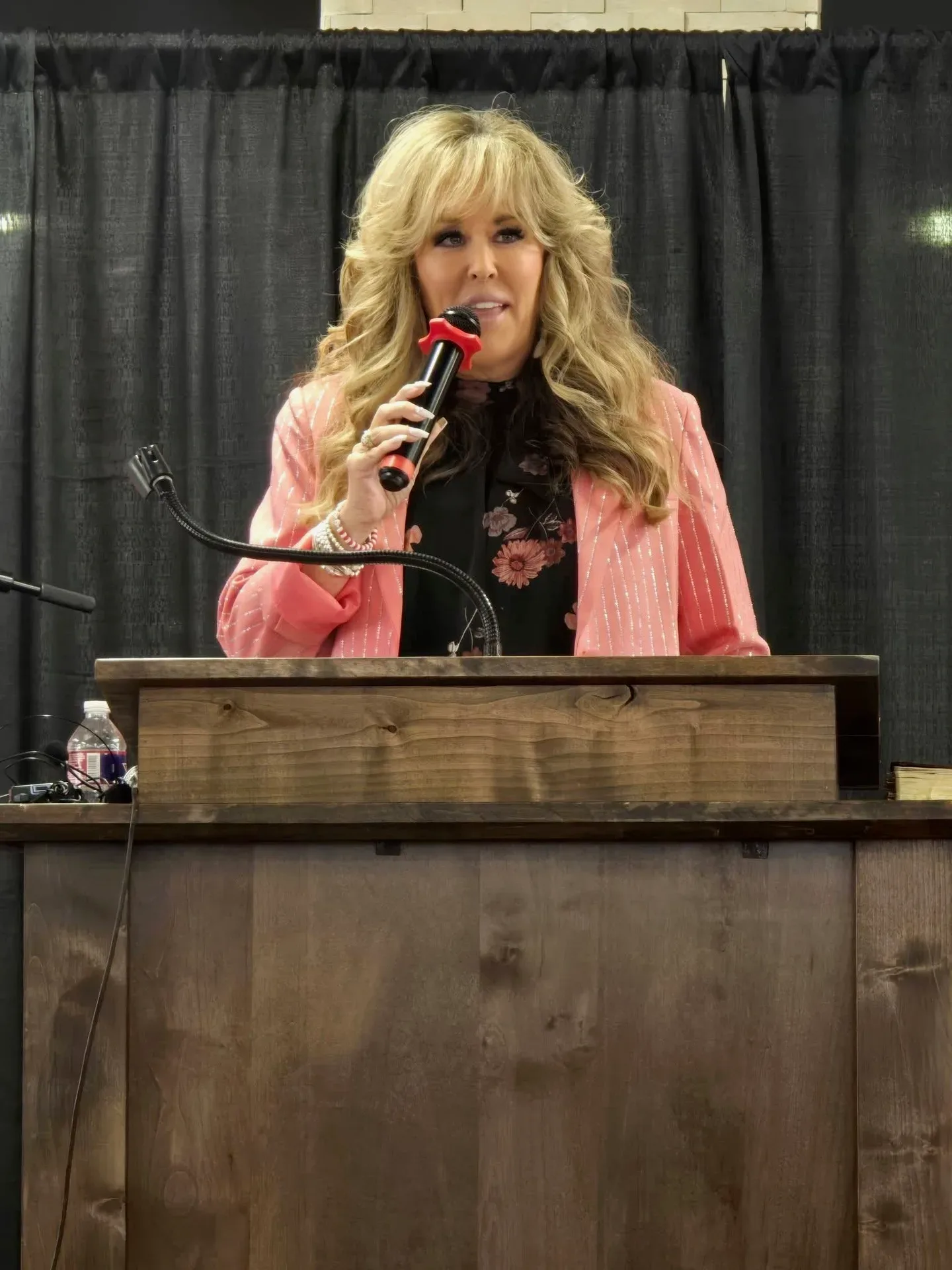 Lisa Copeland speaking at a podium behind a wooden lectern