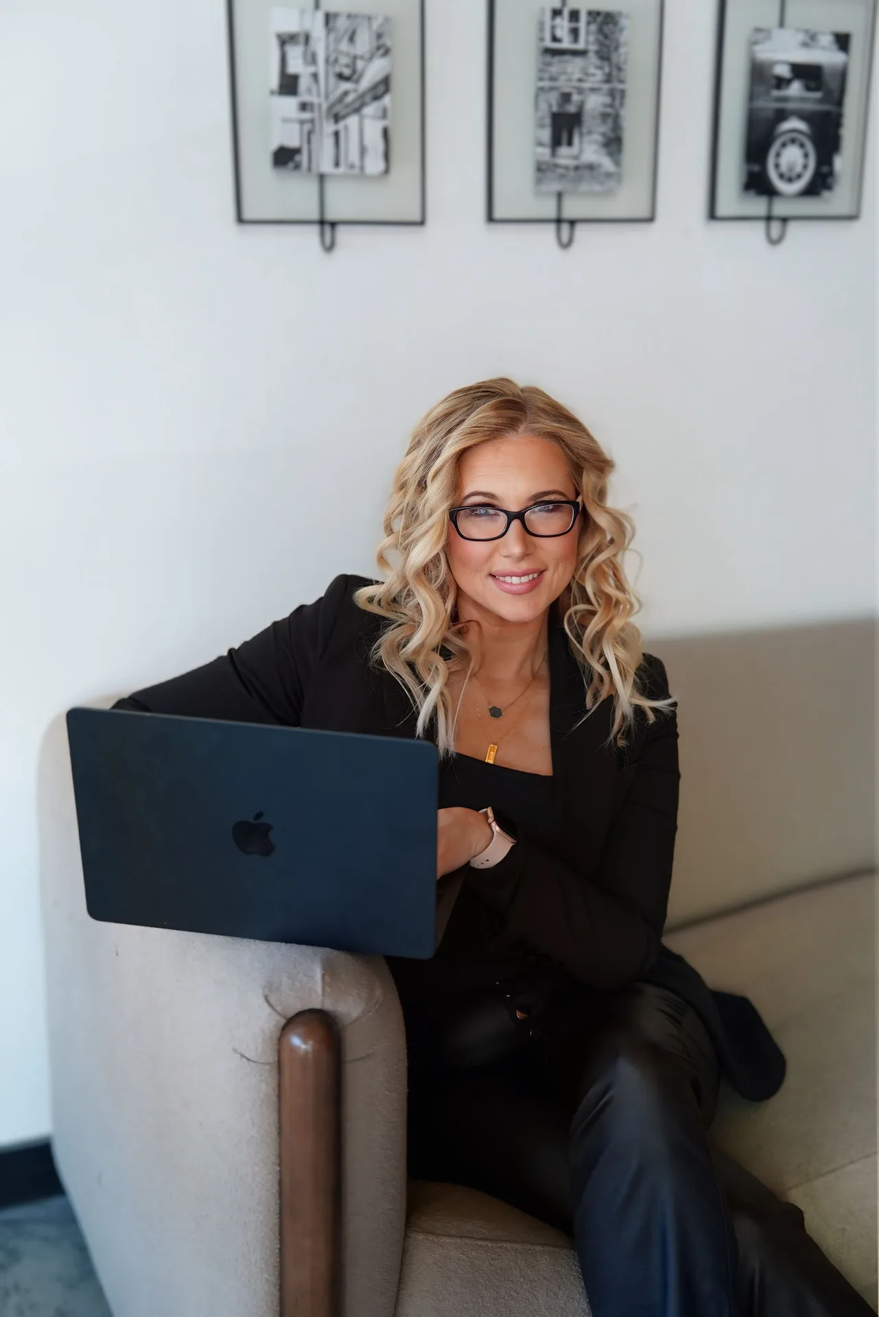 Melissa Albert working from a sofa with her laptop