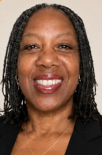 Professional headshot of Diane Taylor, smiling in a dark blazer with a gold necklace