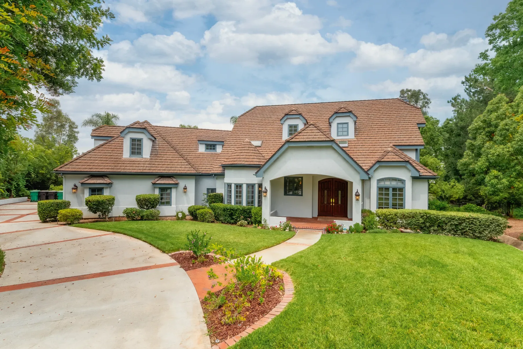 A large two-story family home with a curved driveway, the kind of house you might sell or keep