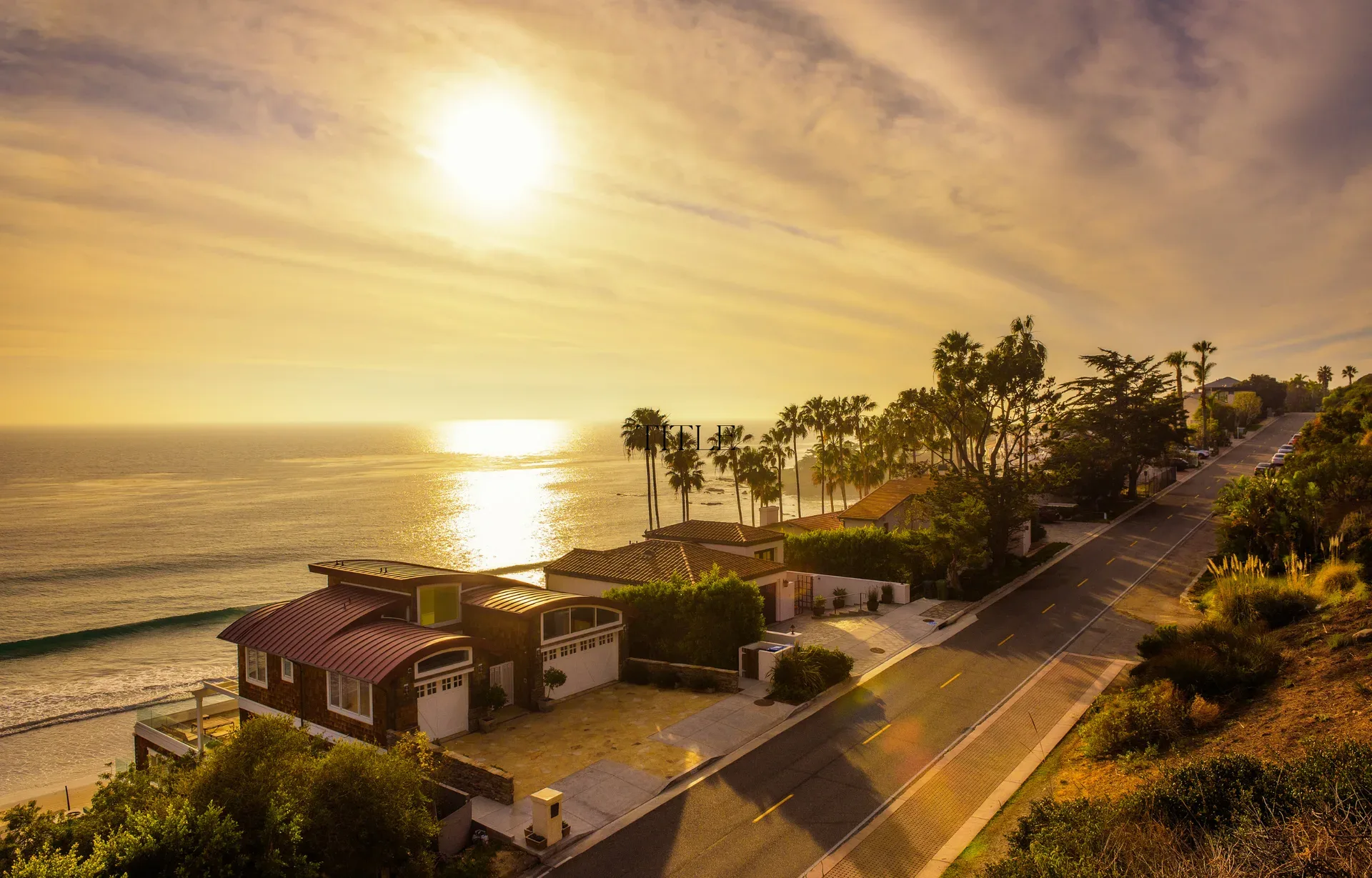 Aerial view of coastal homes along the ocean at sunset