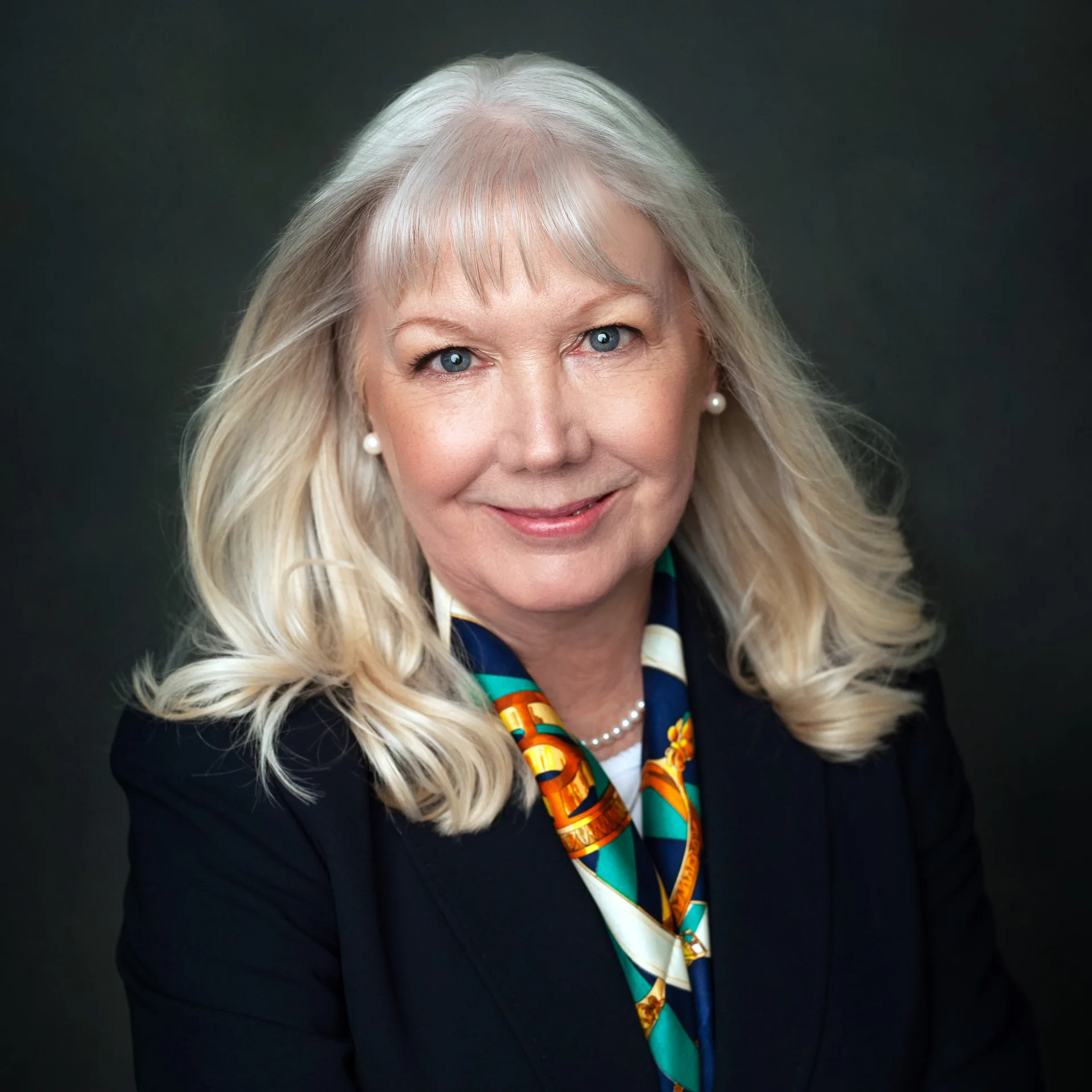 Chris Harris, Publisher and Editor-in-Chief of Good Dog Cincinnati, wearing a dark blazer and a colorful patterned scarf