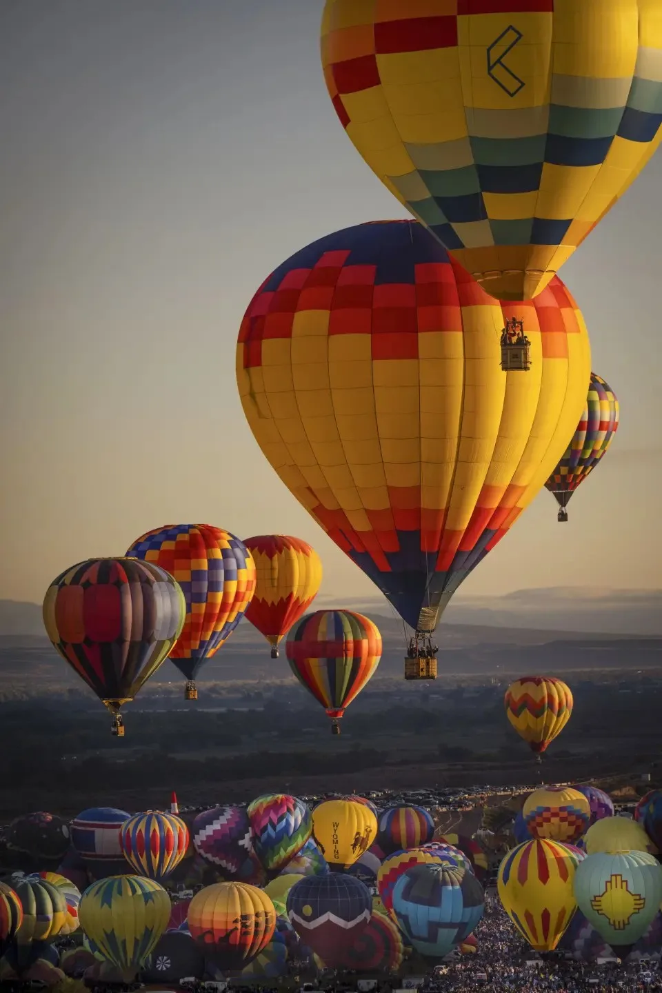 Colorful hot air balloons drifting over the high desert at sunset during the Albuquerque International Balloon Fiesta