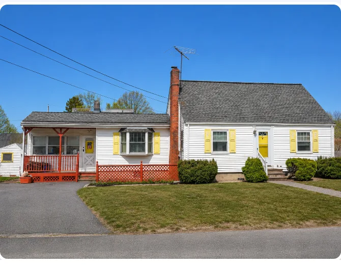 Ida's house, a single-story white home with yellow shutters, a red porch railing, and a brick chimney