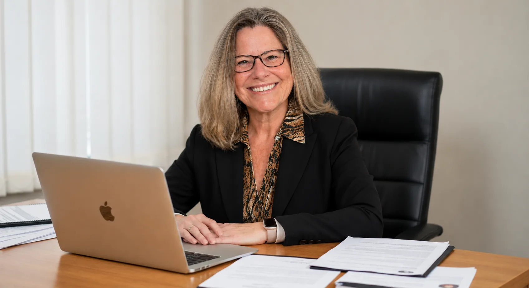 Kathleen sitting at her desk with a laptop and documents