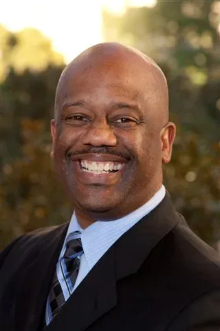 Steve Lockhart, Las Vegas Realtor, smiling in a black suit and light blue dress shirt