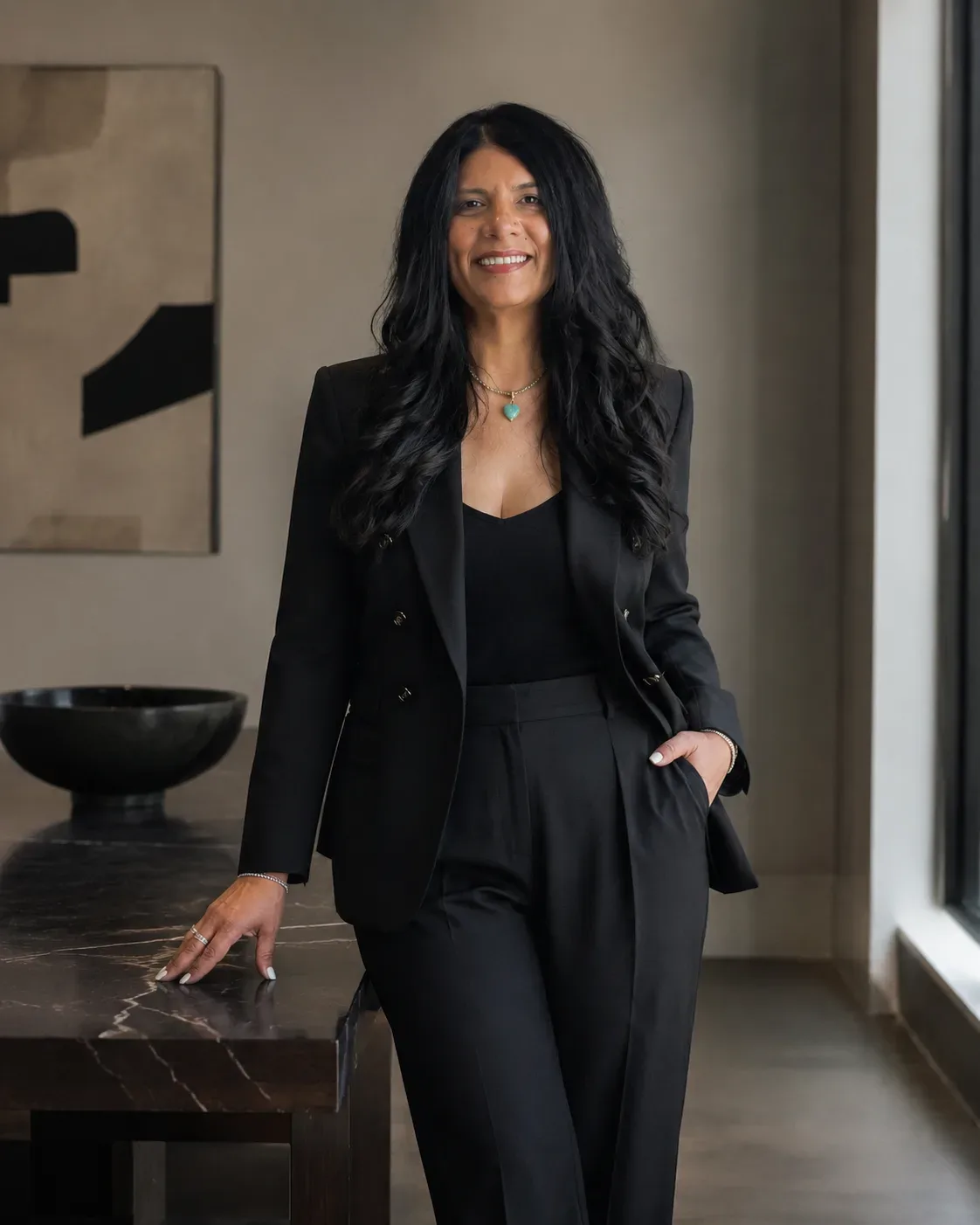 Retrato profesional de Ruth Rivera, coach de bienes raíces, sonriendo con un traje negro