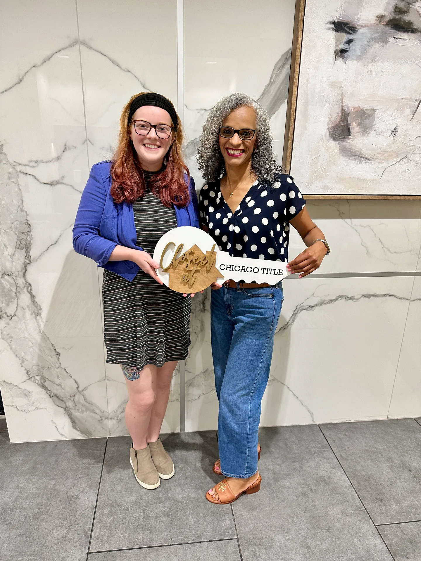 Tami Price with a client holding a large novelty key on closing day