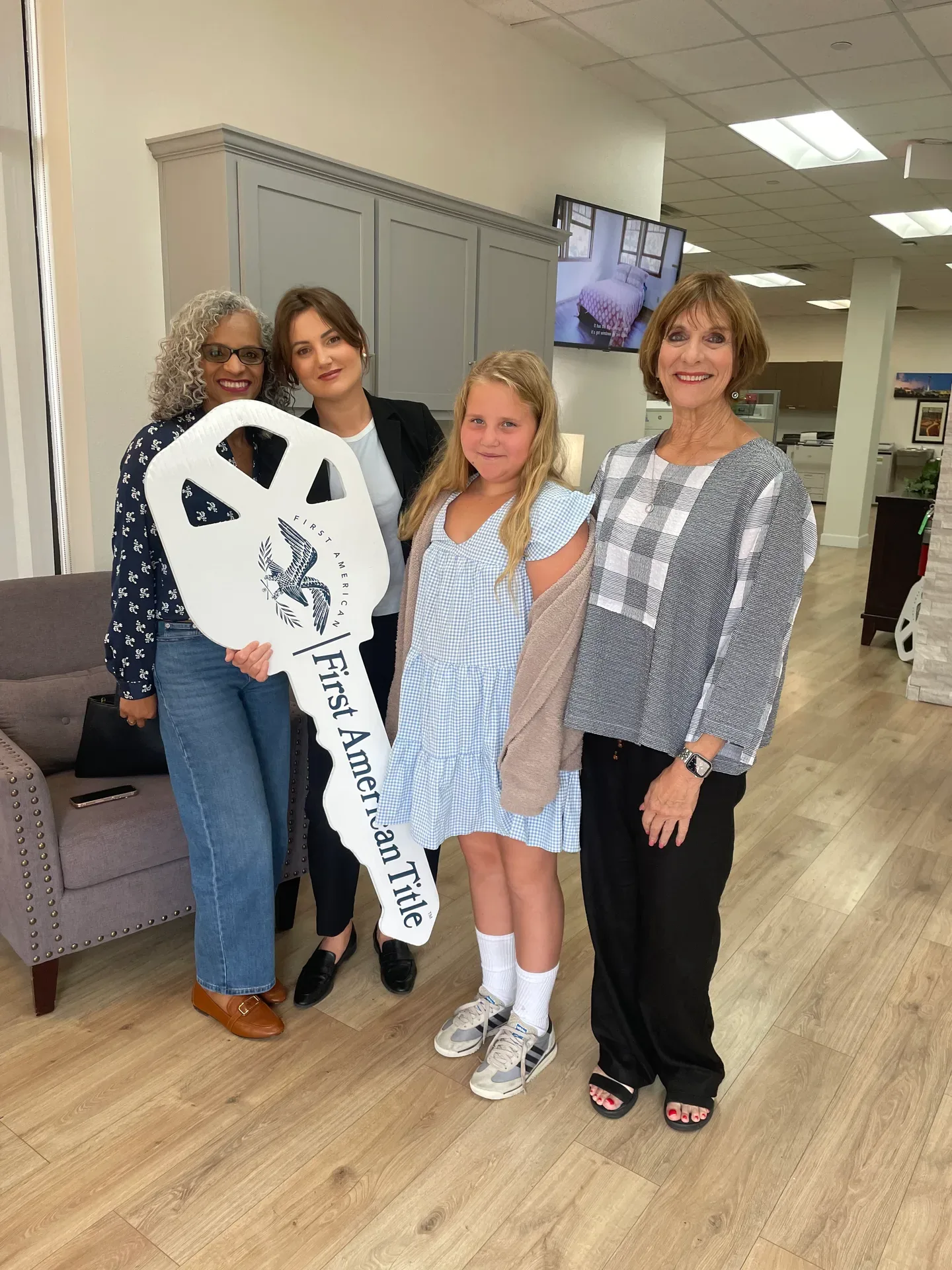Tami Price with clients holding a large title company key on closing day