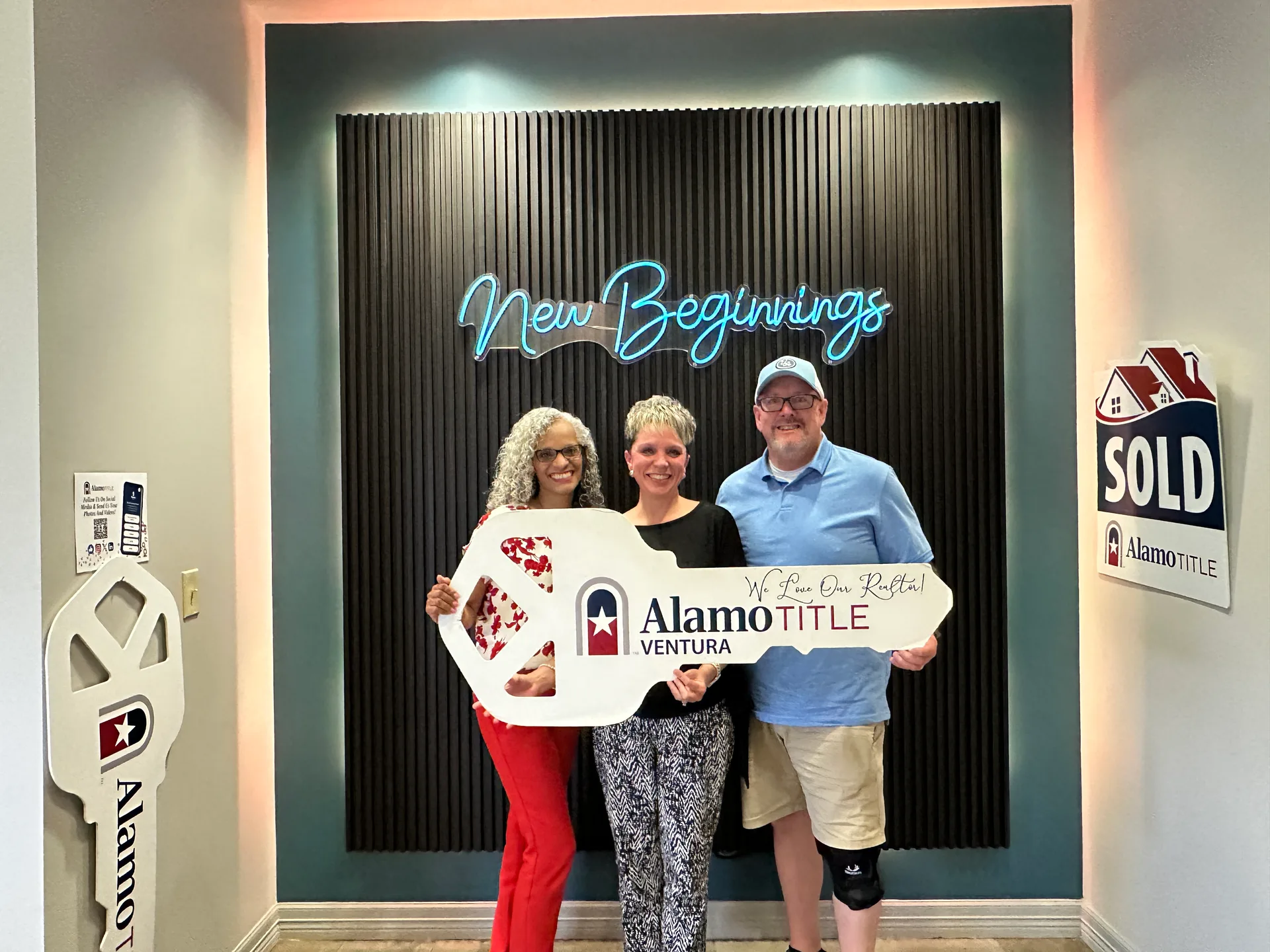Tami Price and clients holding a large novelty key after a home closing