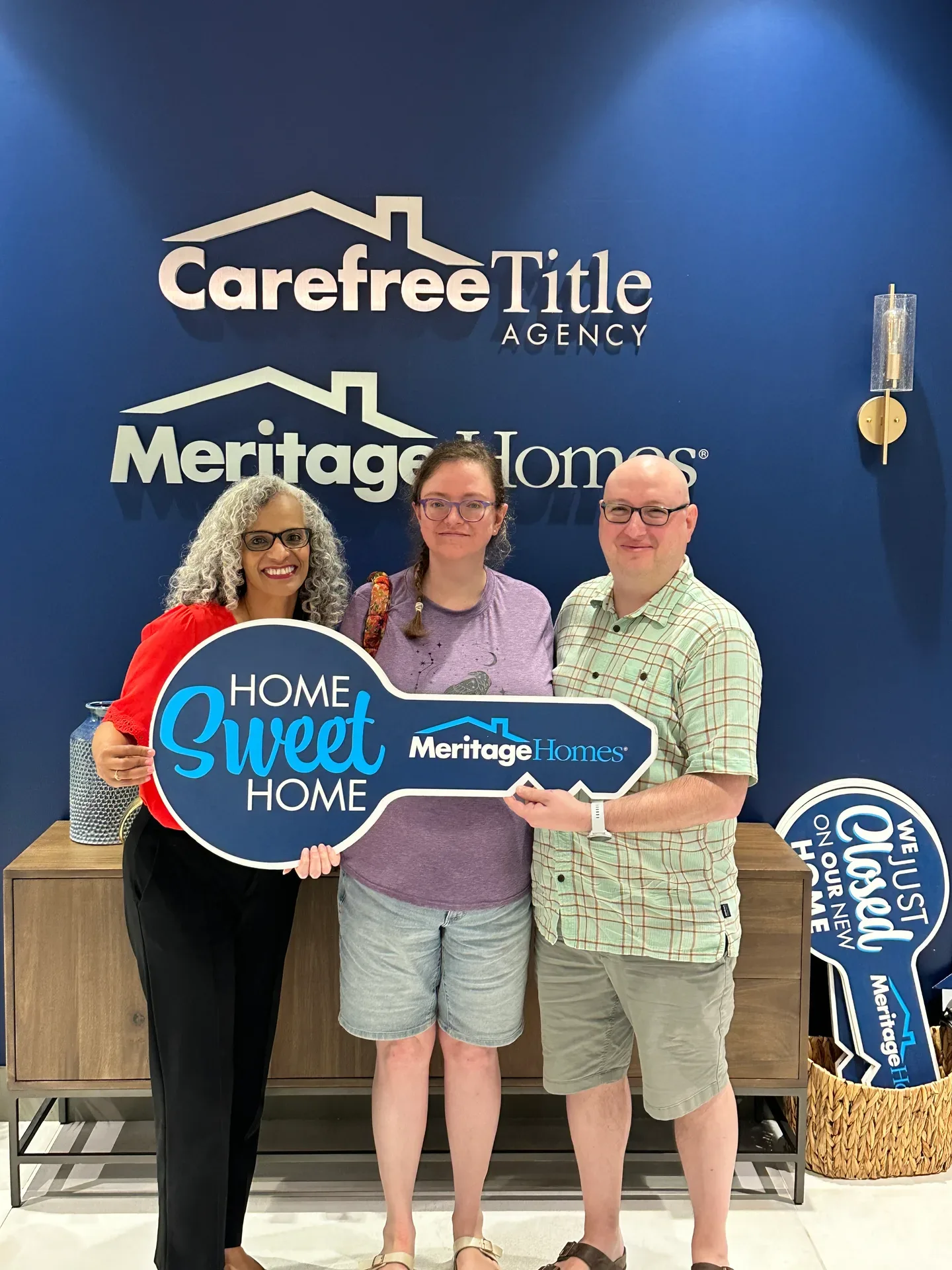 Tami Price with clients holding a Home Sweet Home key on closing day