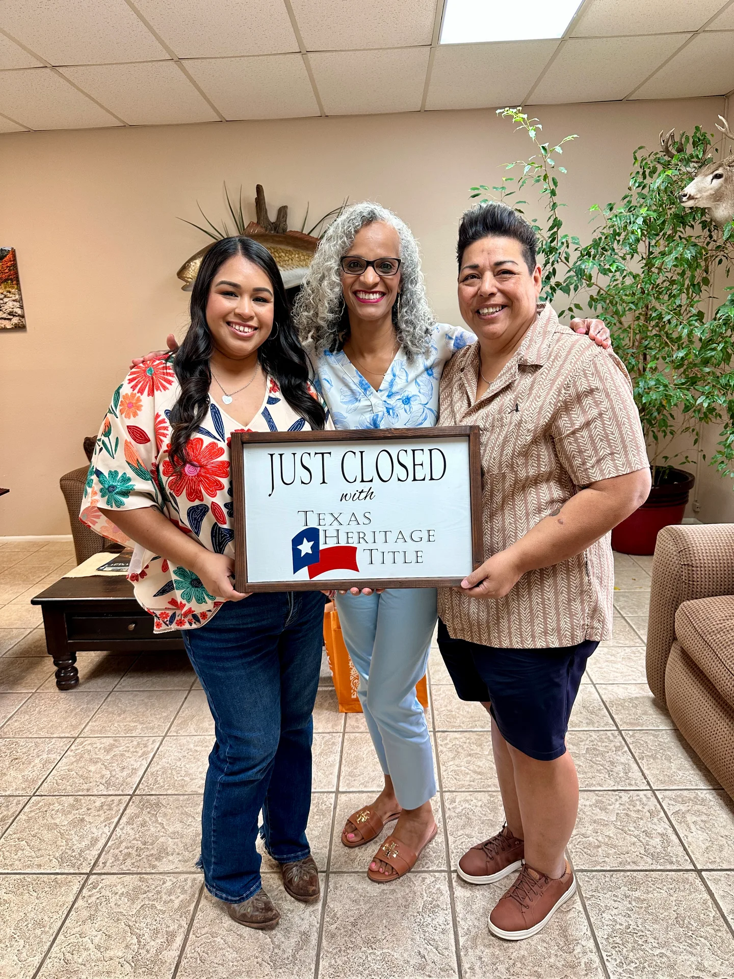 Tami Price with two clients holding a Just Closed sign after closing day