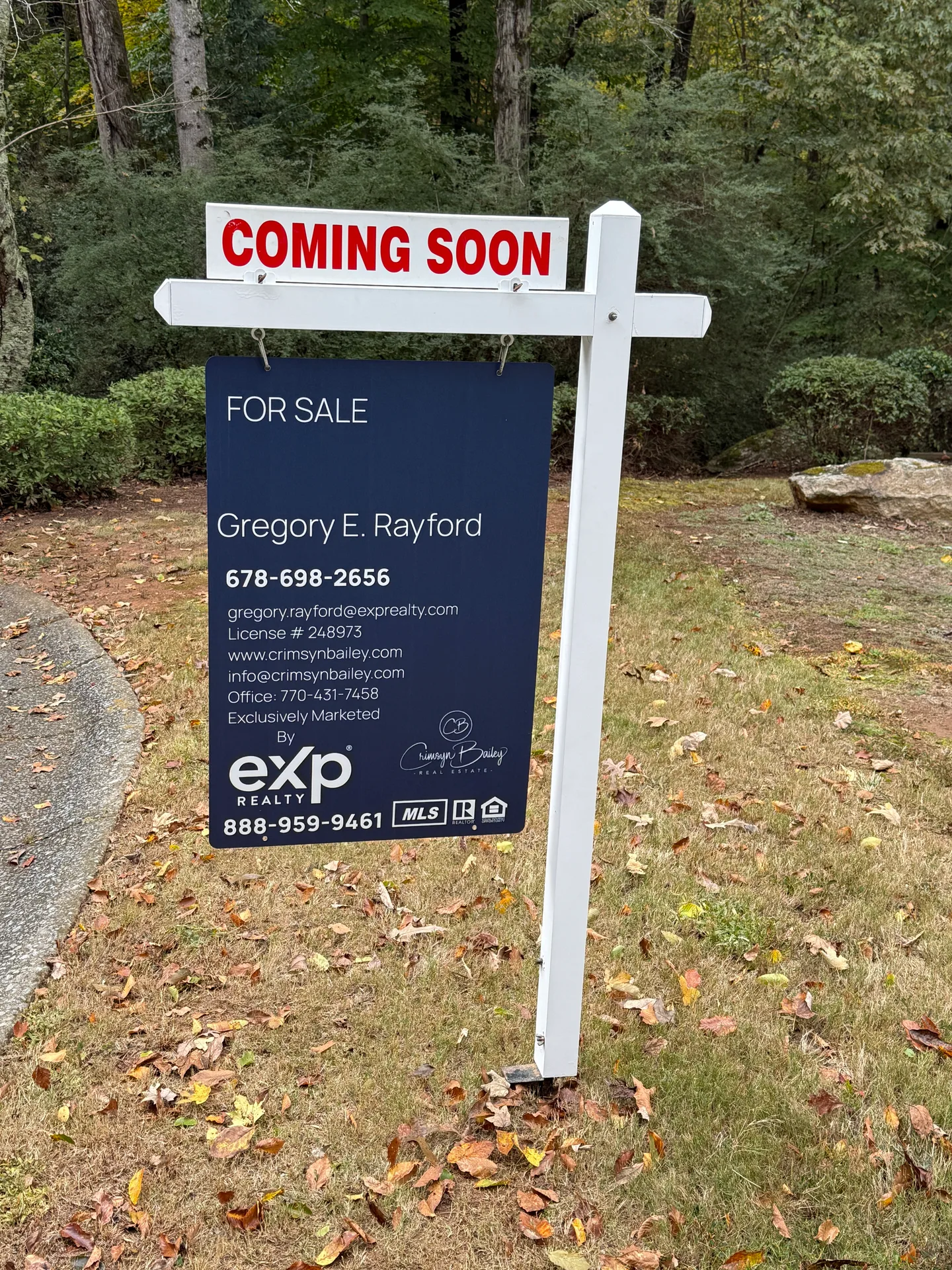 A real estate Coming Soon sign with Greg Rayford's contact details on a grassy lawn