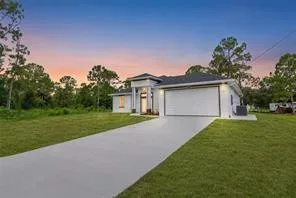 A single-story modern suburban home at dusk with a manicured lawn in Central Florida