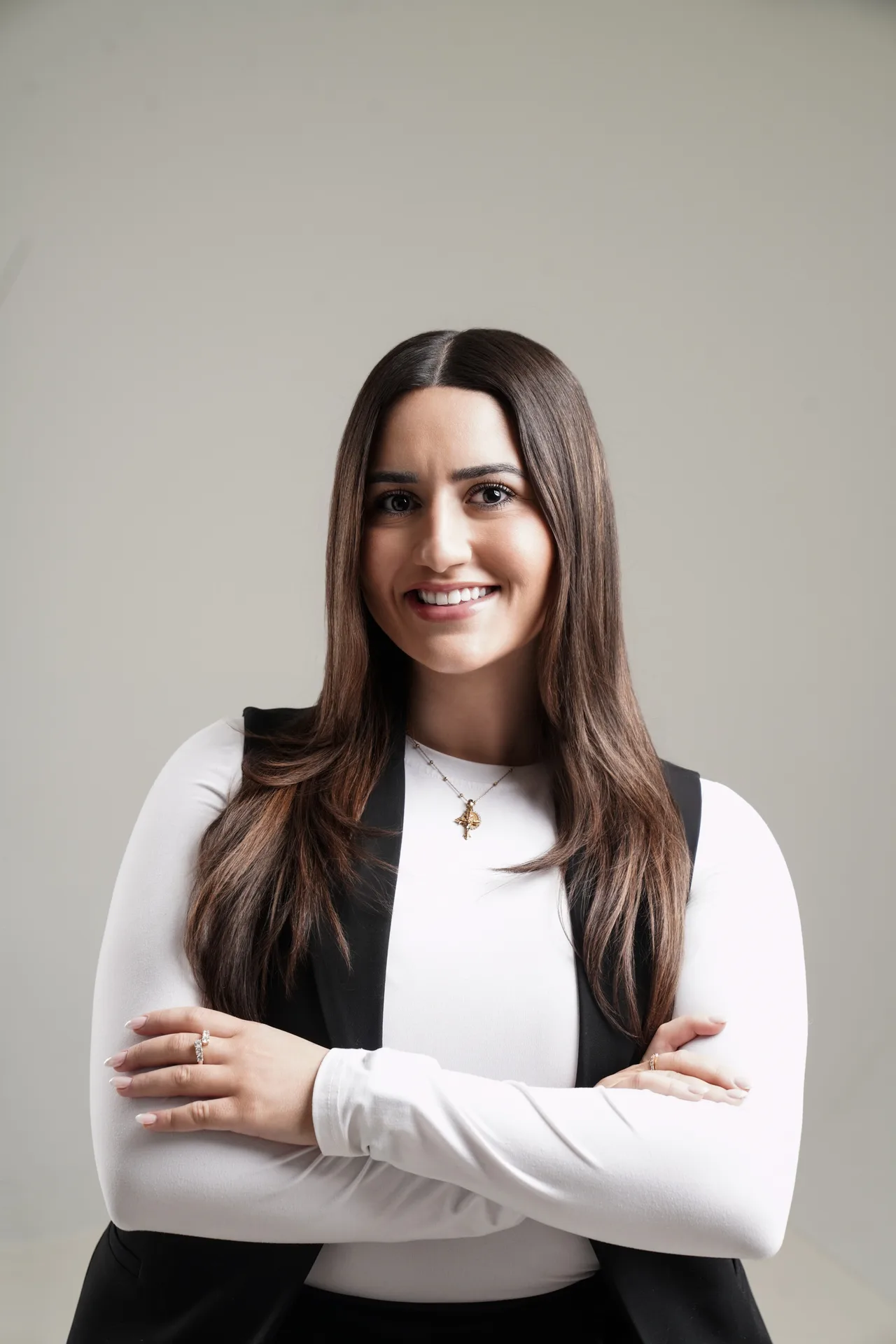 Holly Thomas smiling in a white top and black vest