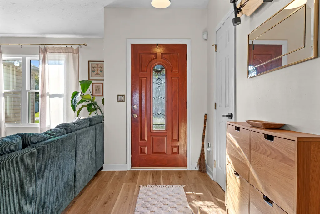 Combined entryway and living room with light hardwood flooring
