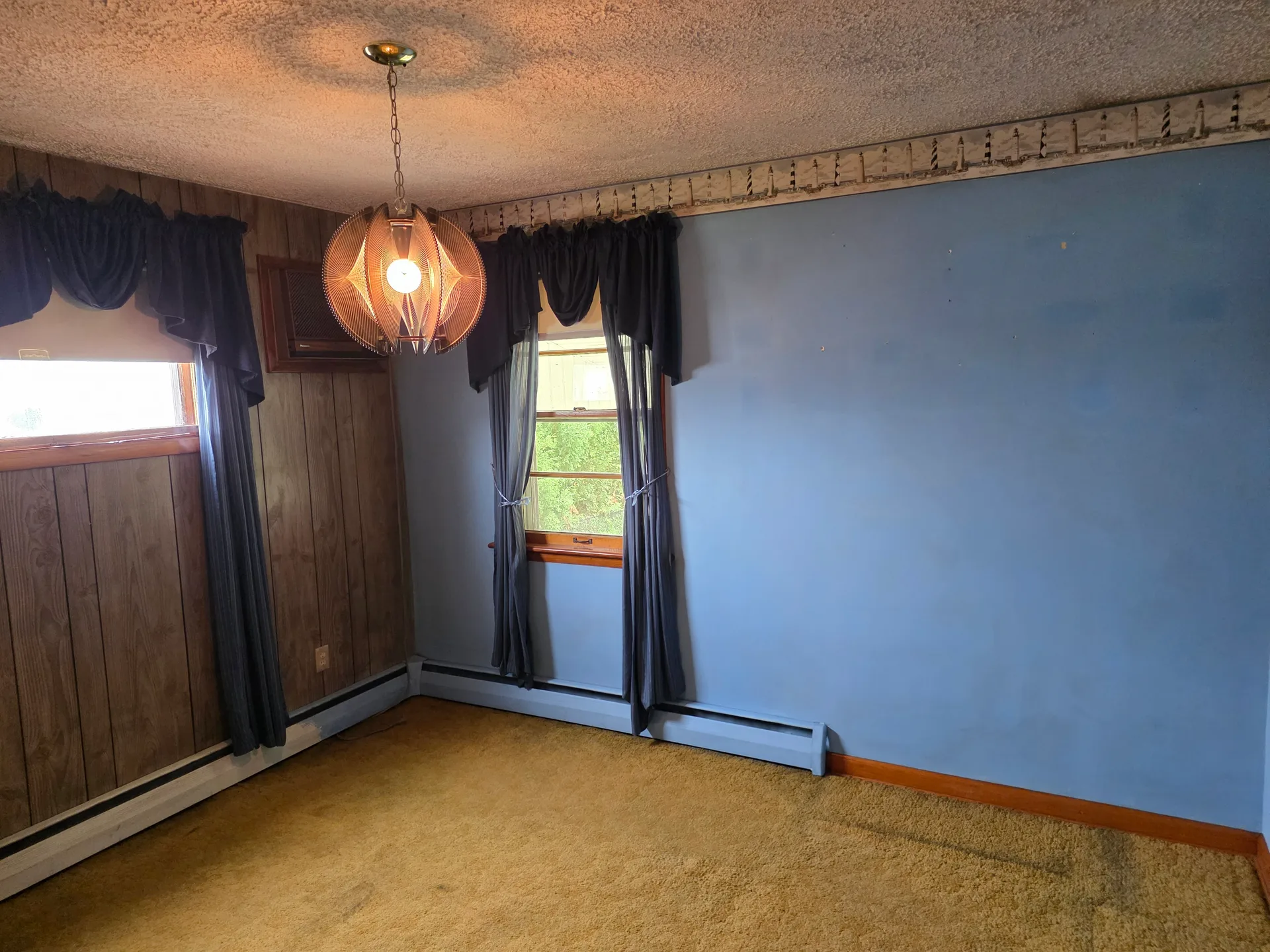 Bedroom with blue walls and wood-paneled accents