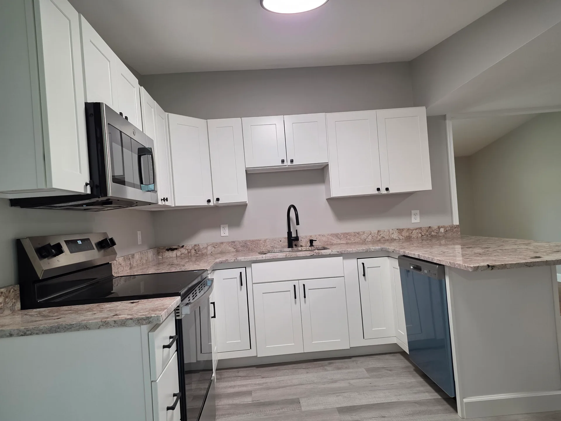 Eat-in kitchen with white shaker cabinets, granite countertops, and stainless steel appliances