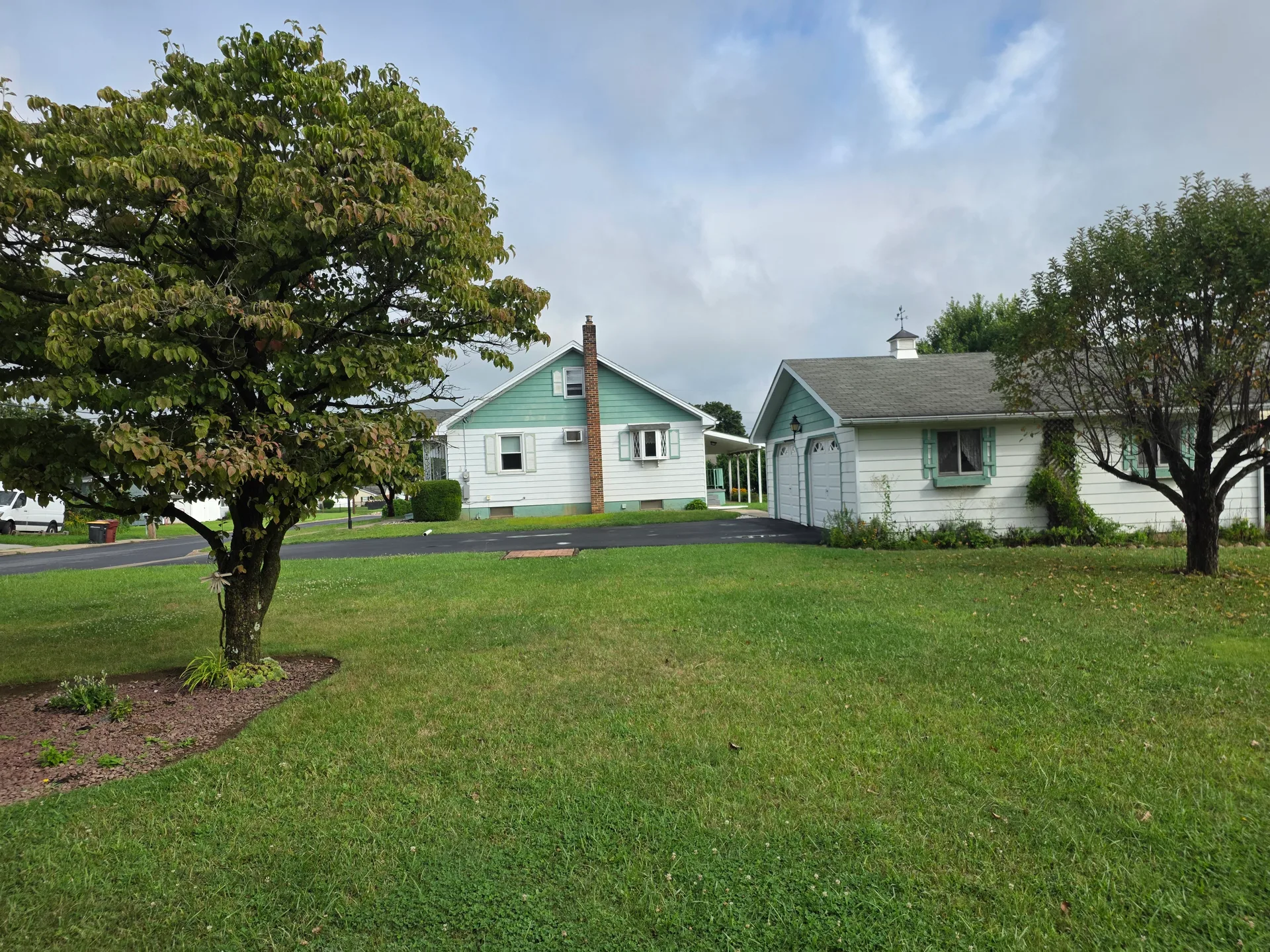 Full exterior view of the ranch-style home with white siding and green accents